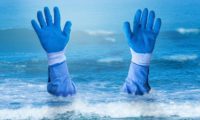 Blue gloved hands drowning in the ocean